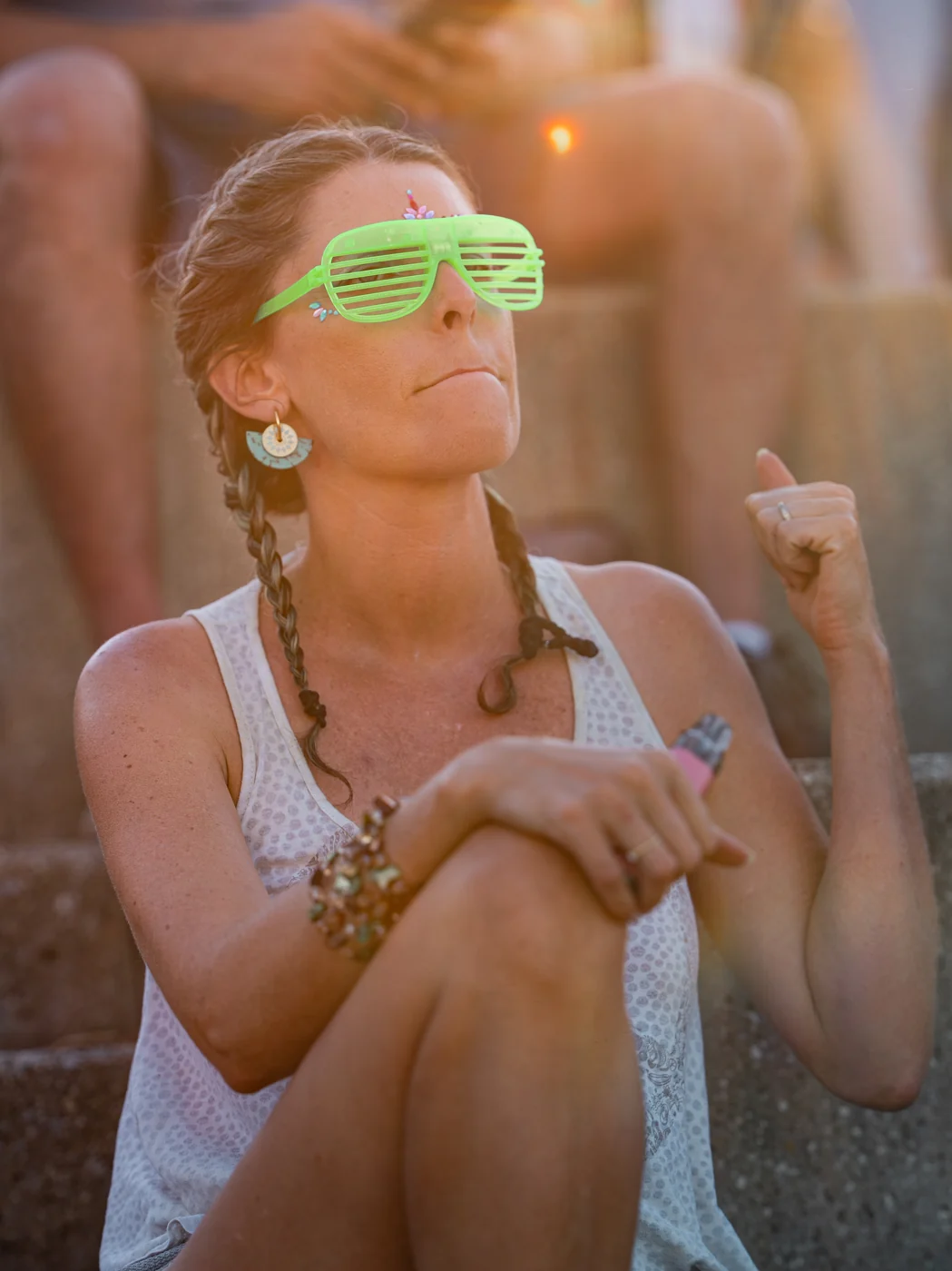 Une festivalière aux lunettes vertes profite du Green Festival au soleil couchant